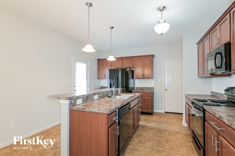 A kitchen with brown cabinets and a granite countertop.