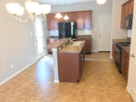 an open kitchen with a large island with granite counter tops