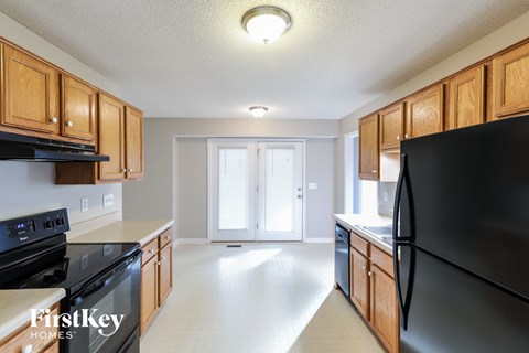 A kitchen with wooden cabinets and black appliances.
