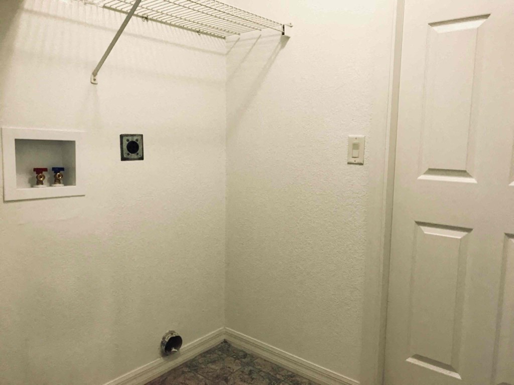 A white bathroom with a towel rack and a door.