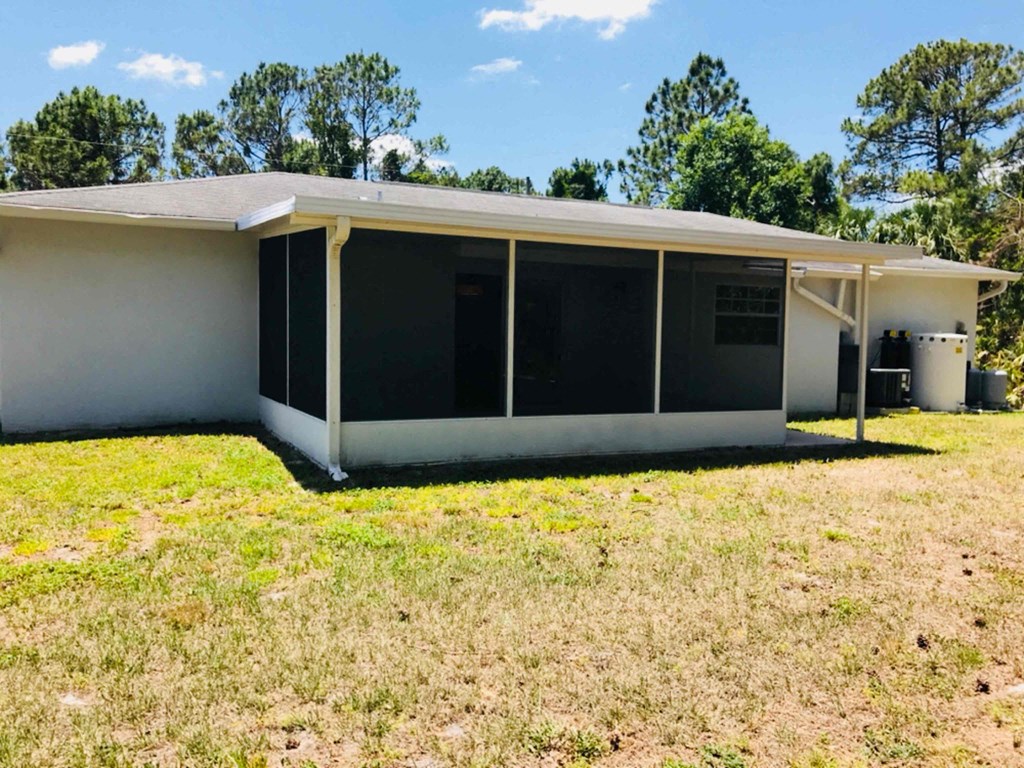A white house with a porch and a covered patio.