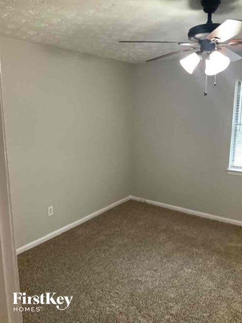 a bedroom with a ceiling fan and a carpeted floor