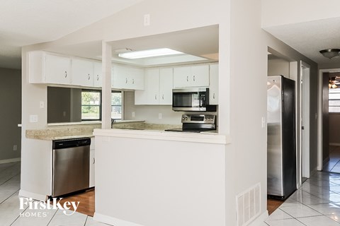 a kitchen with white cabinets and stainless steel appliances