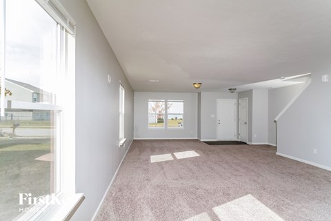 a spacious living room with carpet and a large window