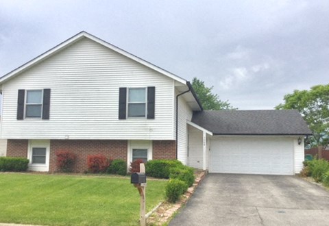 a white house with a yard and a parking meter