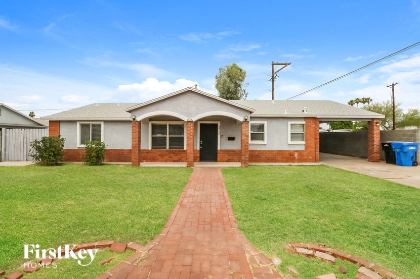 A brick house with a red brick pathway leading to the front door.