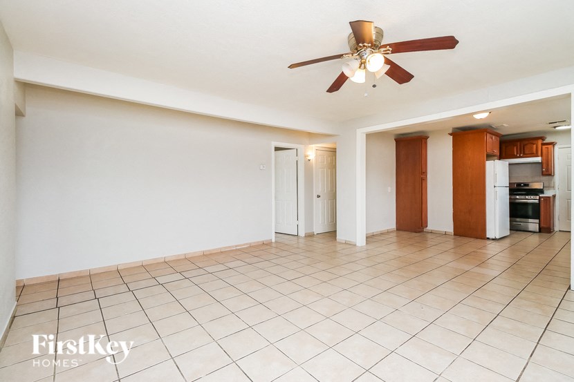 A spacious room with a ceiling fan and tiled floor.