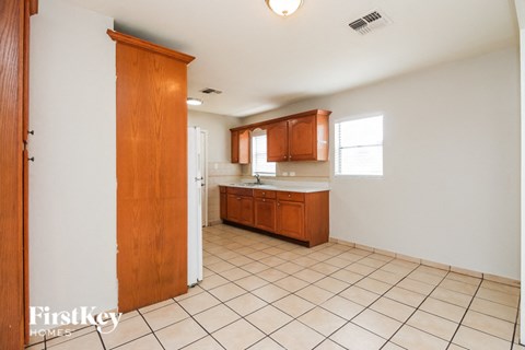 A kitchen with wooden cabinets and a tiled floor.