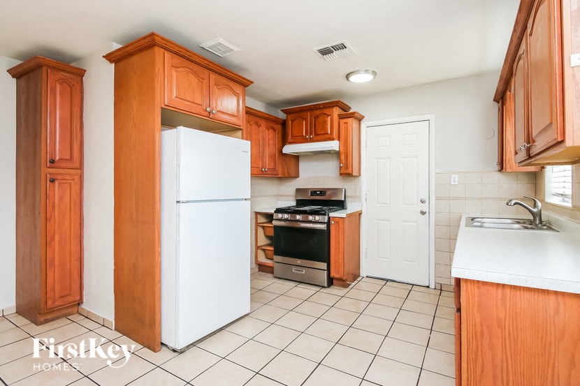 A kitchen with wooden cabinets and white appliances.