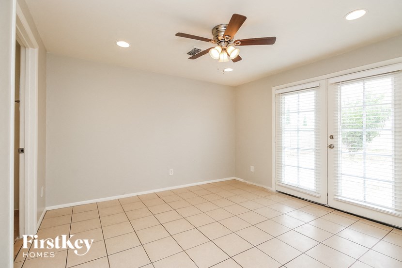 A room with a ceiling fan and tiled floor.
