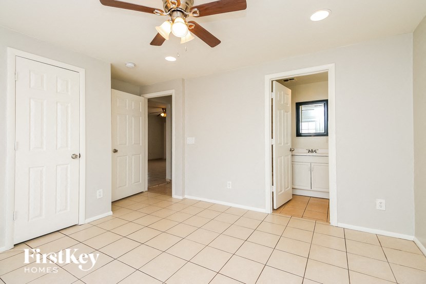 A spacious room with a ceiling fan and tiled flooring.