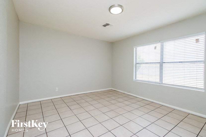 A room with a tiled floor and a window with blinds.