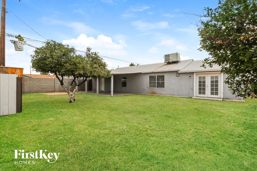 A house with a lawn and a tree in front of it.
