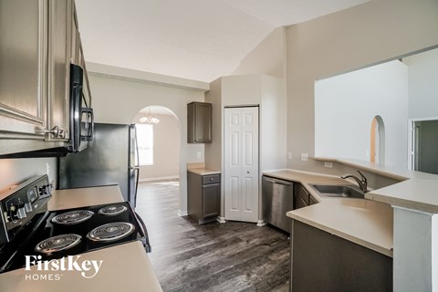 a kitchen with a stove and a refrigerator and a sink