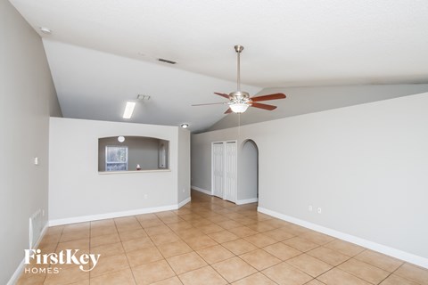 a living room with a ceiling fan and a tiled floor
