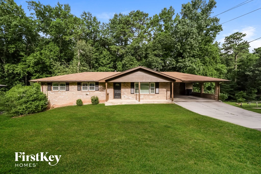 a brick house with a lawn and a driveway