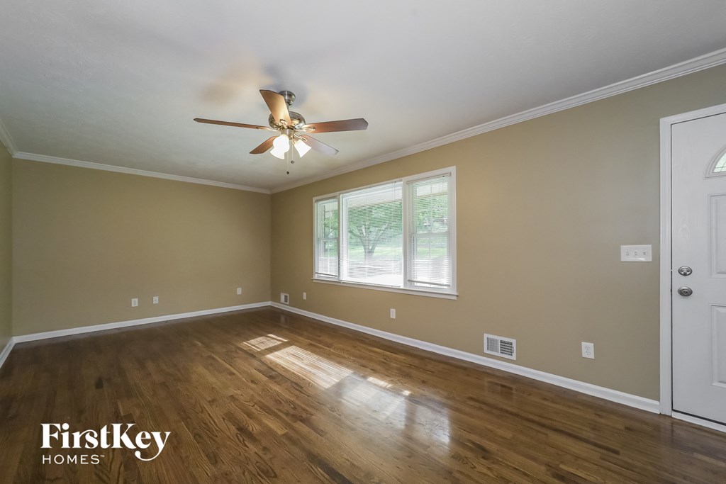 the master bedroom has a ceiling fan and hardwood floors