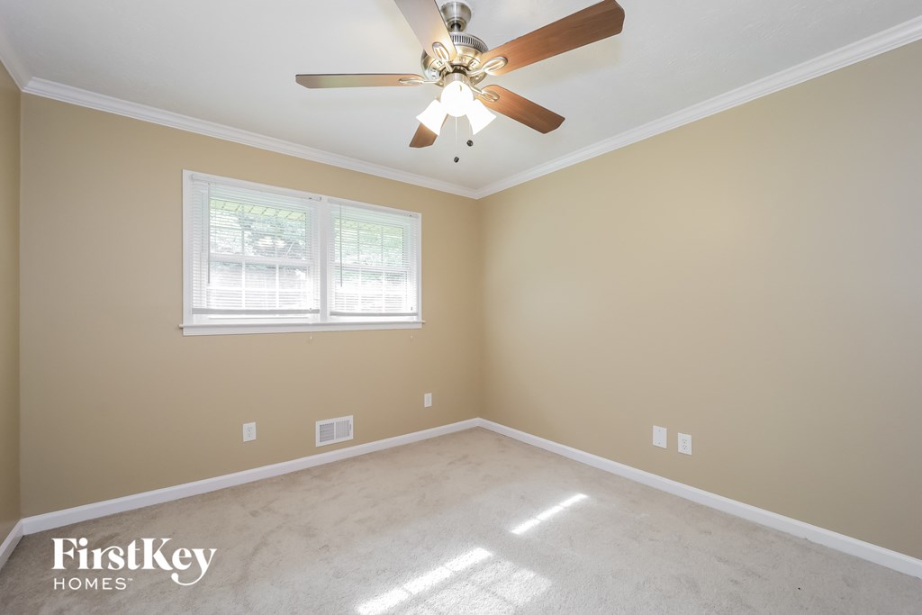 a empty room with a ceiling fan and a window