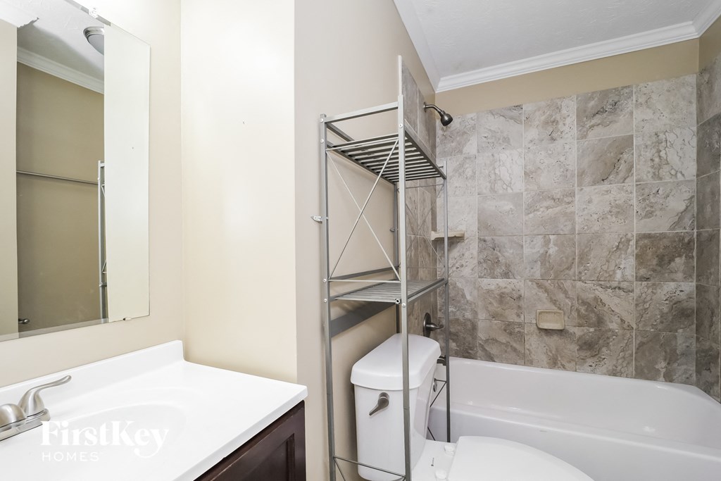 a small bathroom with a shower and a sink and a toilet