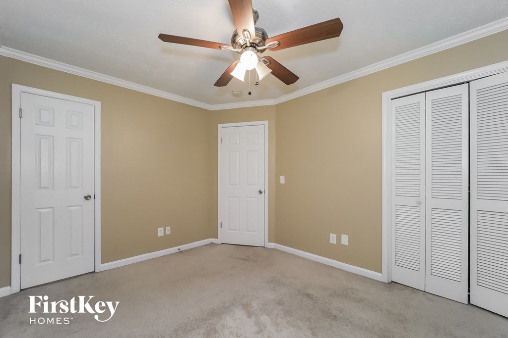 a bedroom with two closets and a ceiling fan