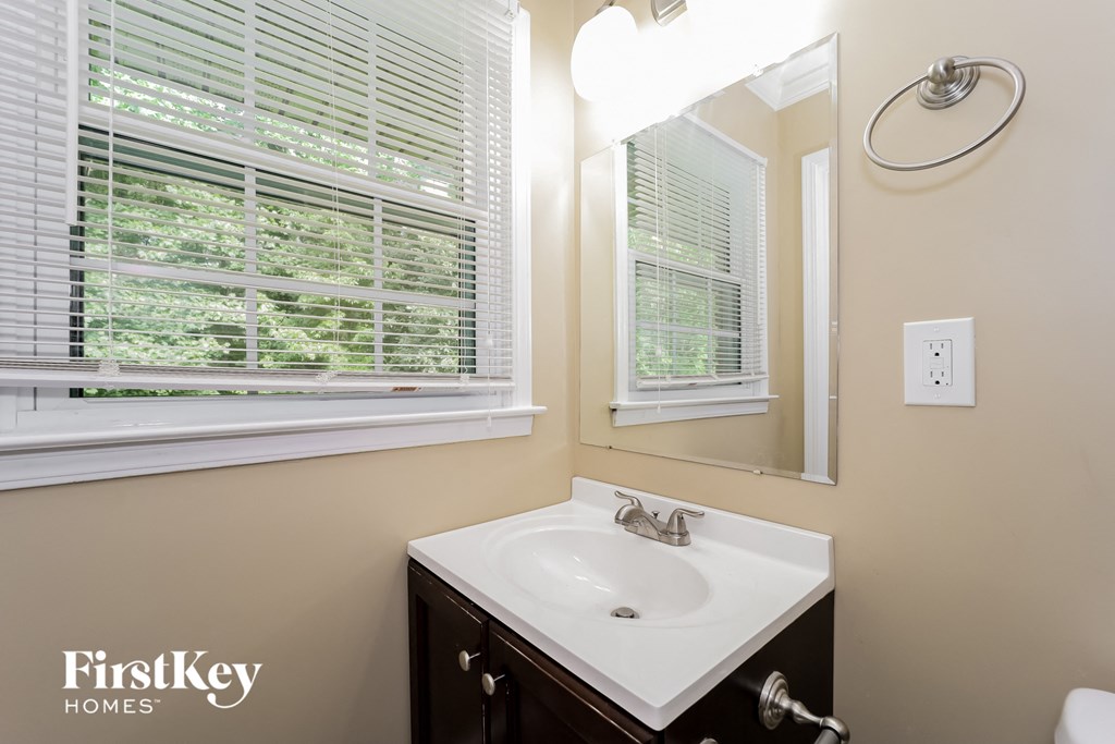 a bathroom with a sink and a mirror and a window
