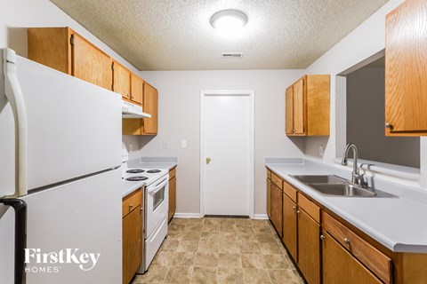 A kitchen with a white refrigerator and wooden cabinets.