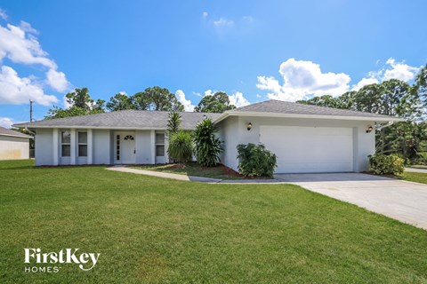 a white house with a lawn and a driveway