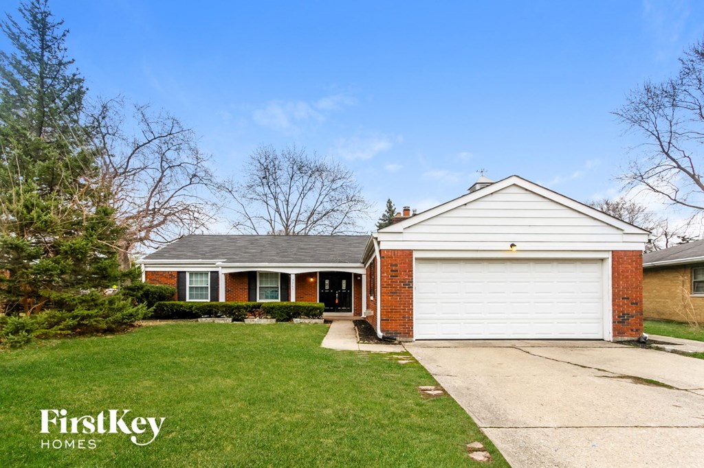 a home with a lawn and a white garage door