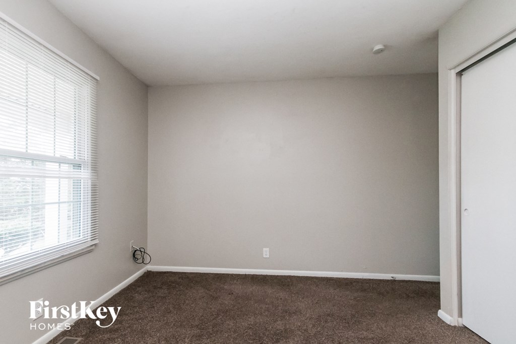 a bedroom with a carpeted floor and a large window