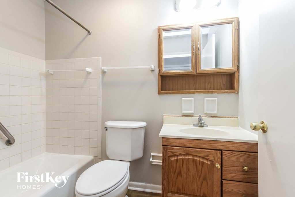 a bathroom with a toilet sink and tub and a mirror