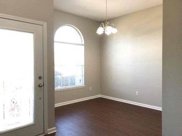 an empty living room with a window and a door