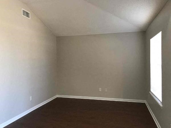 an empty room with a wood floor and a window