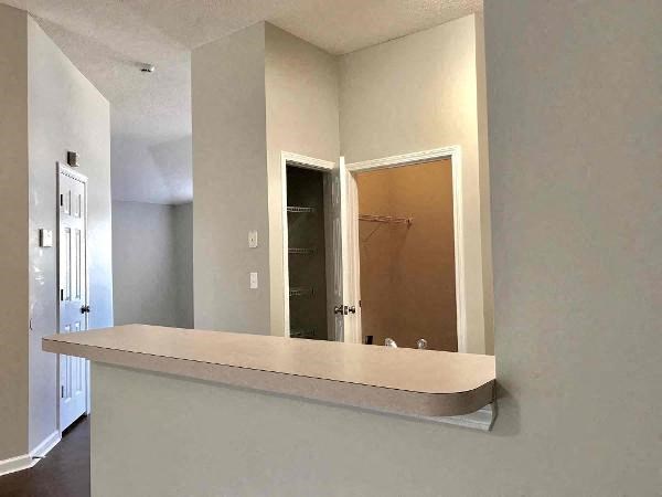 an empty kitchen with a counter and a mirror