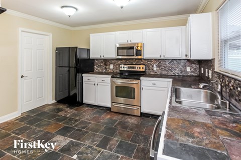 a kitchen with white cabinets and stainless steel appliances