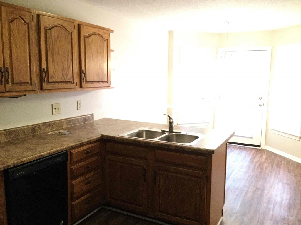 an empty kitchen with wooden cabinets and a sink
