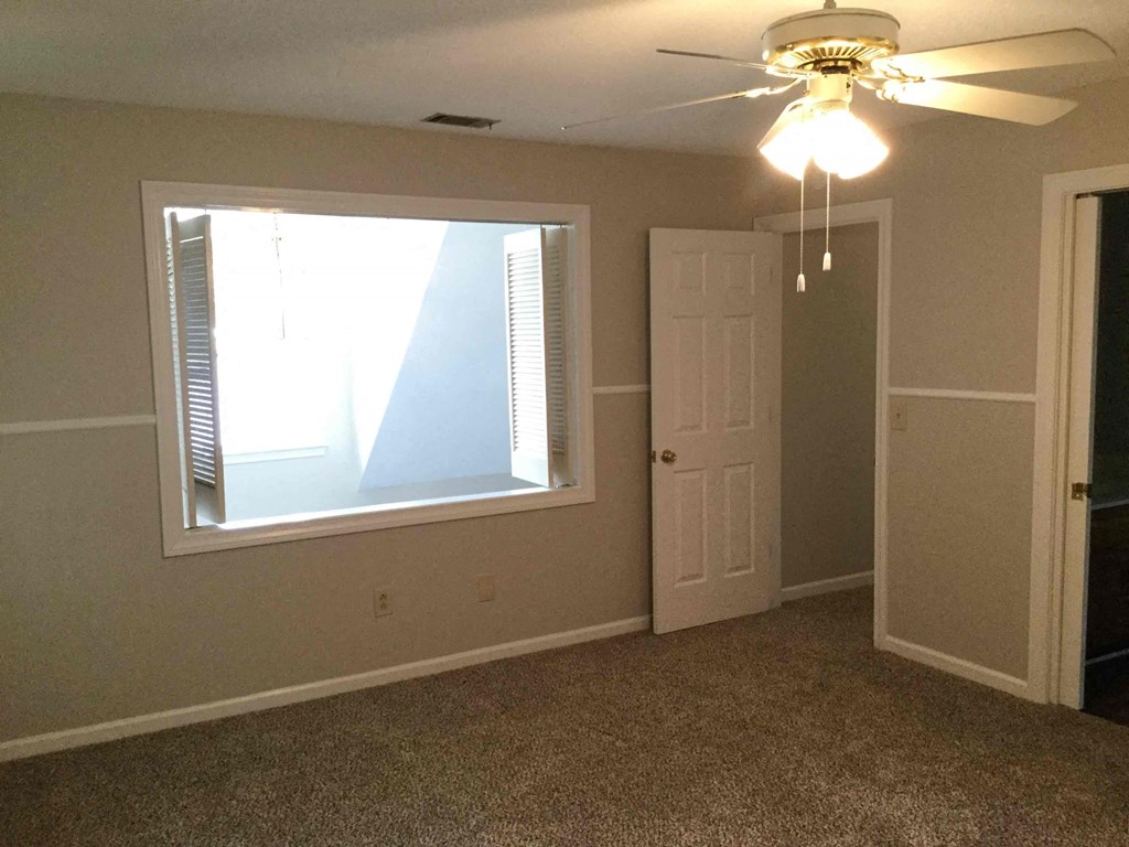 a empty room with a window and a ceiling fan