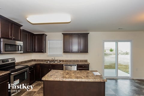 A kitchen with brown cabinets and a granite countertop.