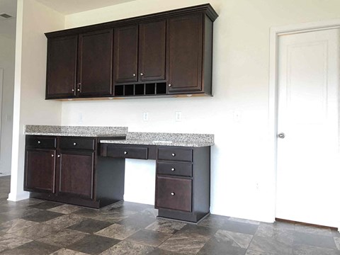 A kitchen with dark brown cabinets and a checkered floor.
