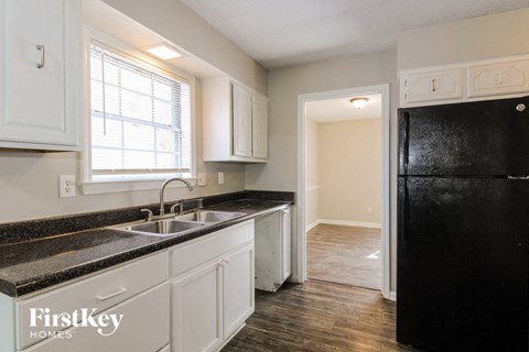 a kitchen with white cabinets and black appliances and a black refrigerator