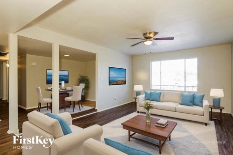 A living room with a white couch and a wooden coffee table.