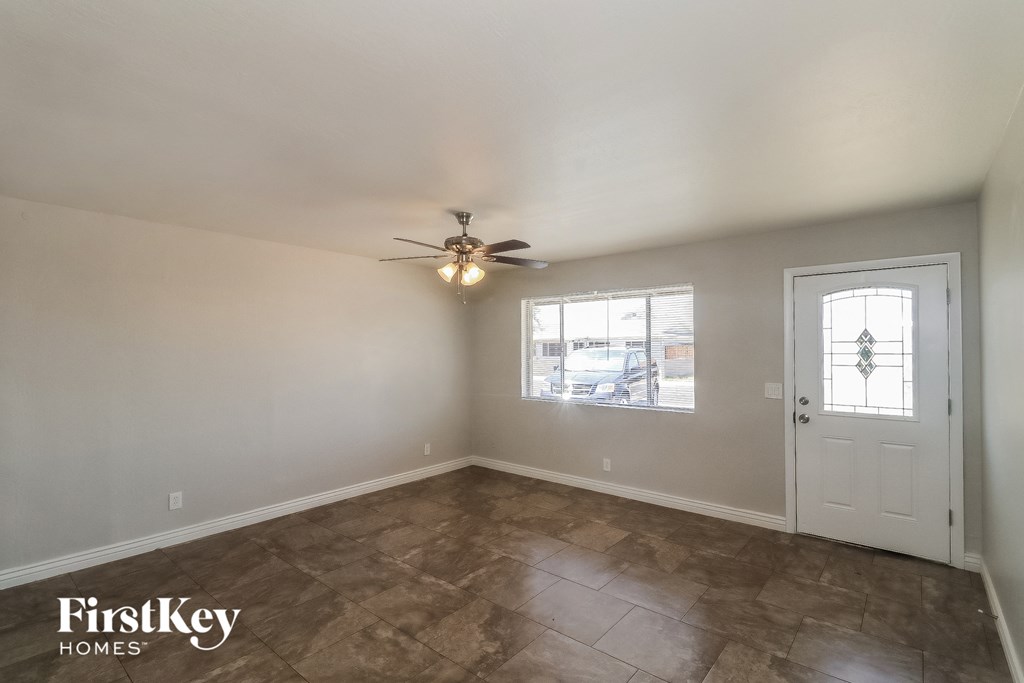 the living room of an empty house with a ceiling fan