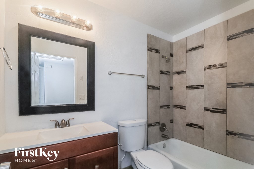 a bathroom with a shower toilet and sink and a mirror