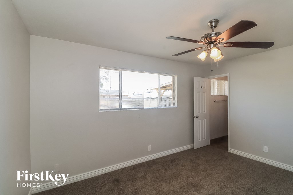 a bedroom with a ceiling fan and a window