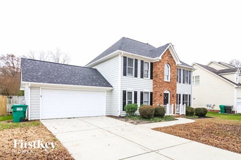 A two-story house with a brick facade and a white garage door.