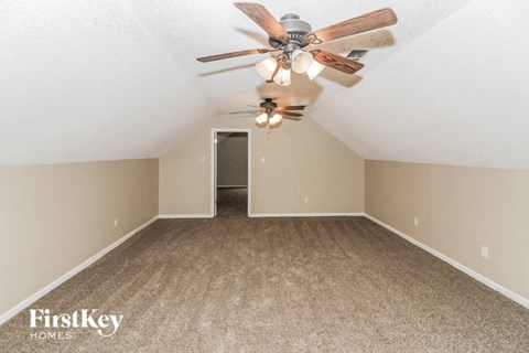a bedroom with a ceiling fan and a carpet