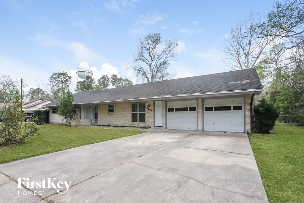 a white brick house with a garage and a water tower