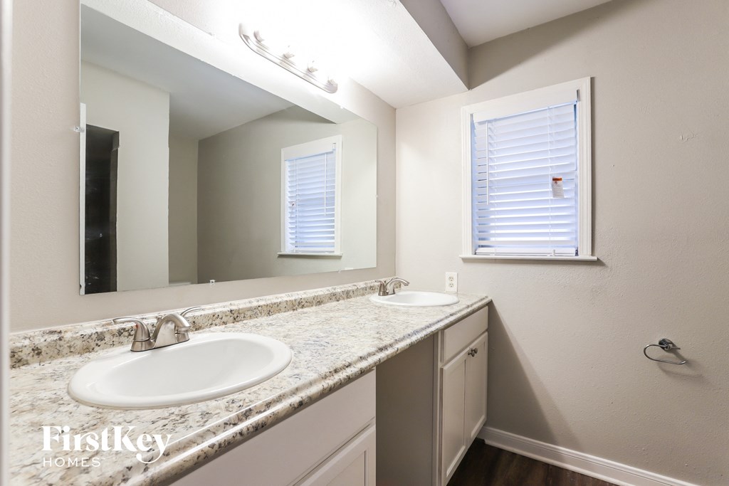 a bathroom with two sinks and a large mirror