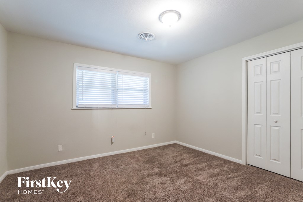 a bedroom with carpet and a window and white doors