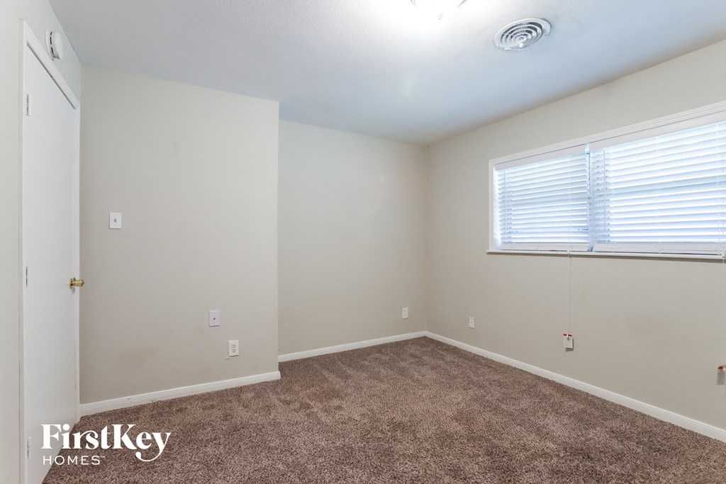 a bedroom with a carpeted floor and a window
