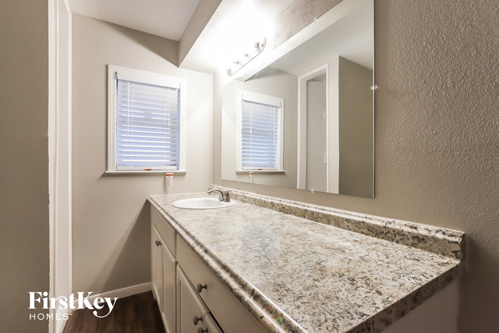 a bathroom with a granite counter top and a sink